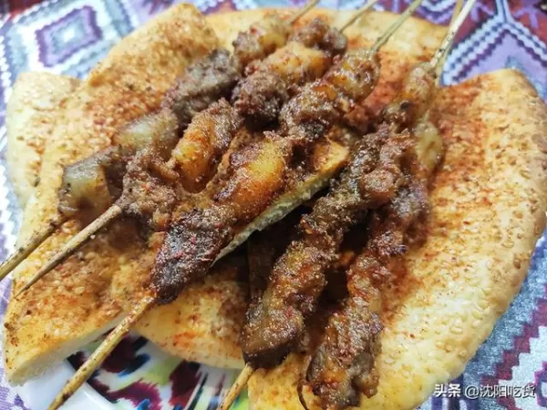 再說回烤饢,上面撒了一層辣椒麵,而羊肉串老闆進屋實在看不下去了